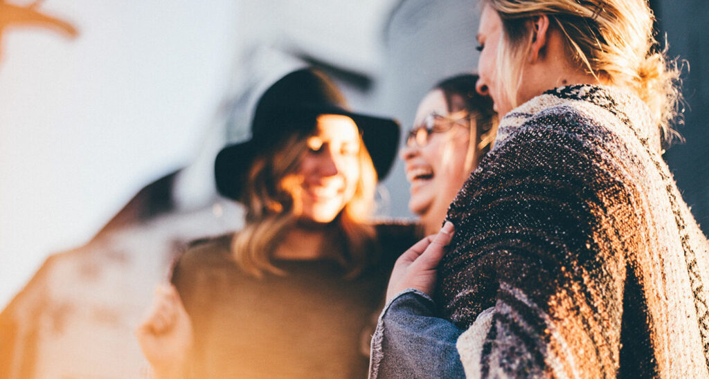 Drei Freundinnen stehen lachend beisammen. Joyce Meyer