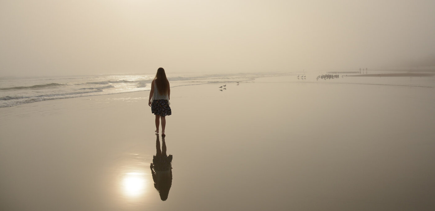 Frau beim Sonnenuntergang am Strand