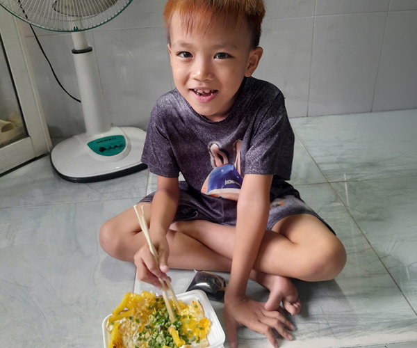 Hand of Hope: Ein asiatischer Junge freut sich über eine Mahlzeit.